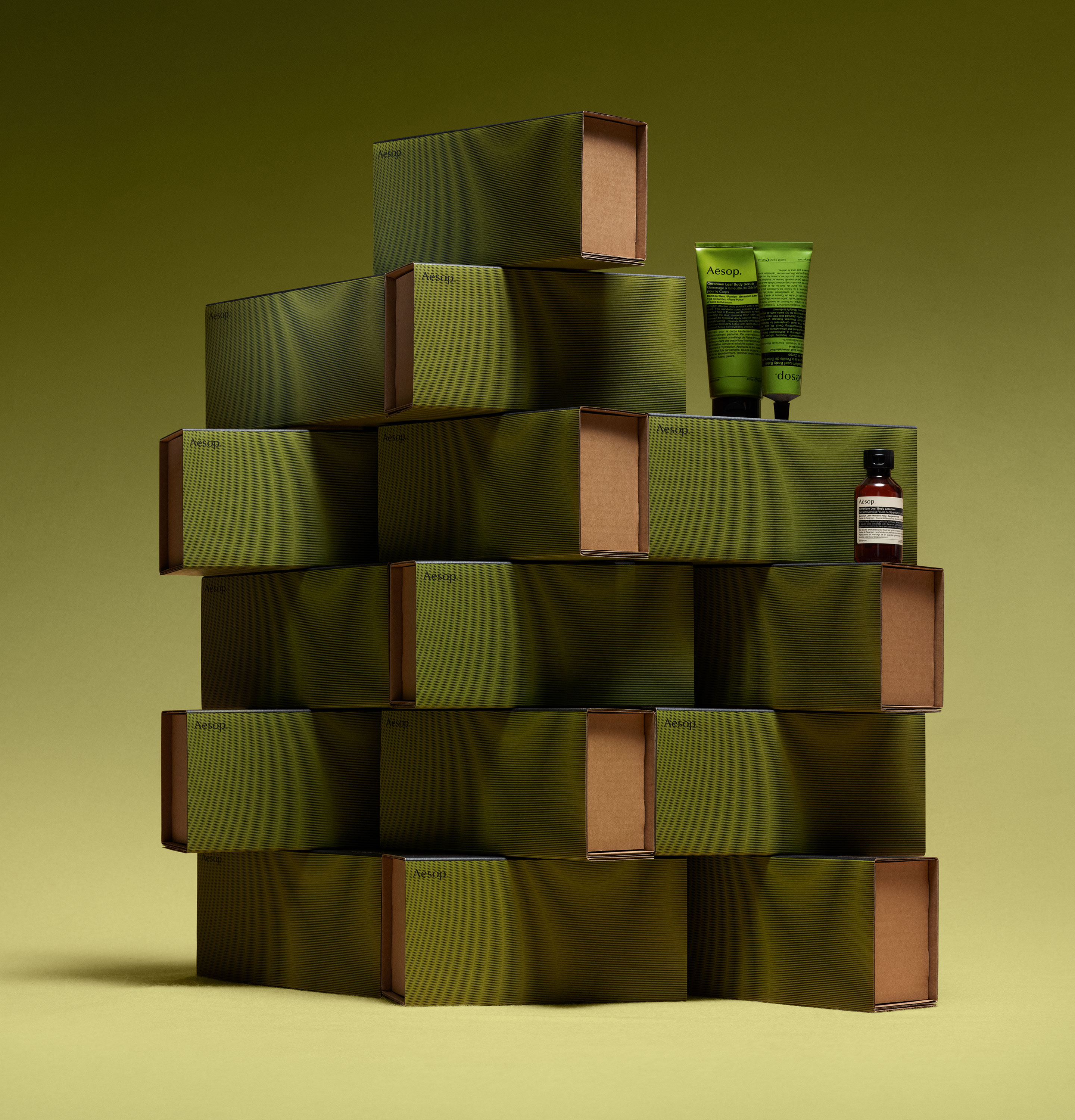 Aesop products placed on a stacked green cardboard boxes.
