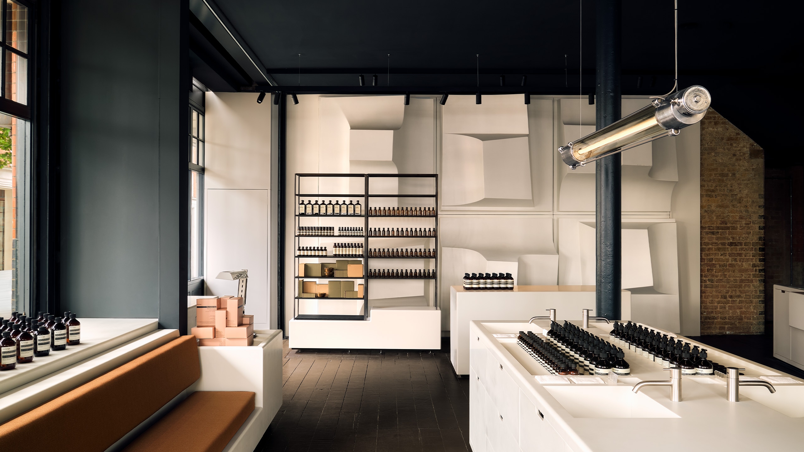 Aesop Spitalfields store interior, geometric volumes—restored in alabaster white—become a striking interior skin, fixed to the walls with a light metal structure.