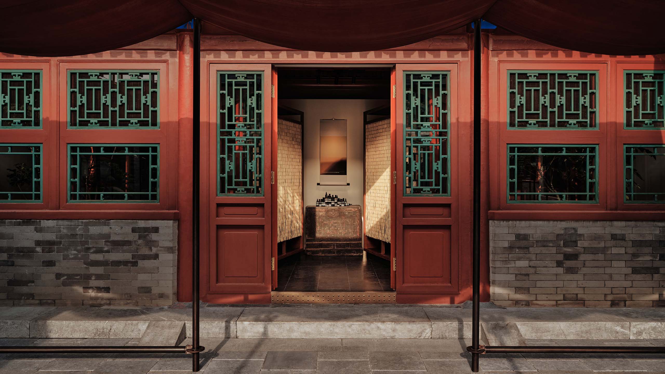 The expansive courtyard beneath the pergola draped in waterproof canvas and crimson xiangyunsha tea silk.