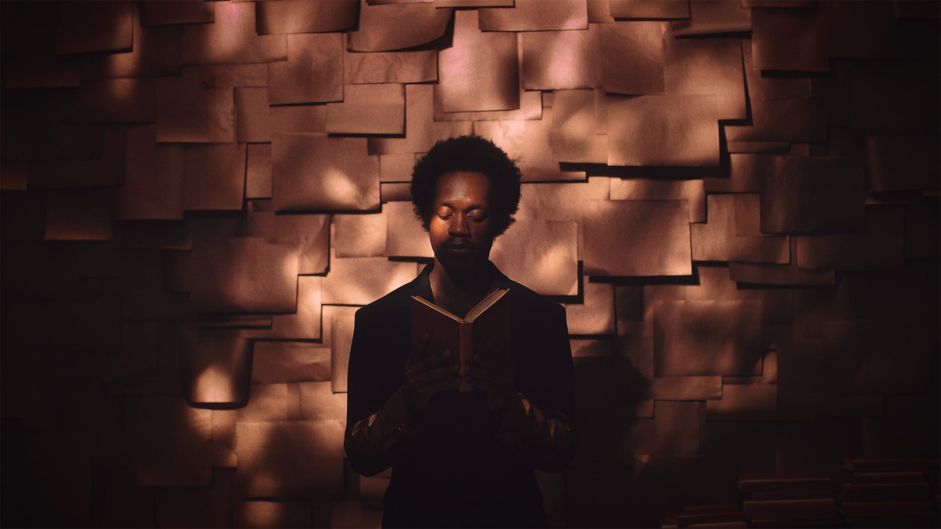 photo of a person sitting in dappled lighting reading a book