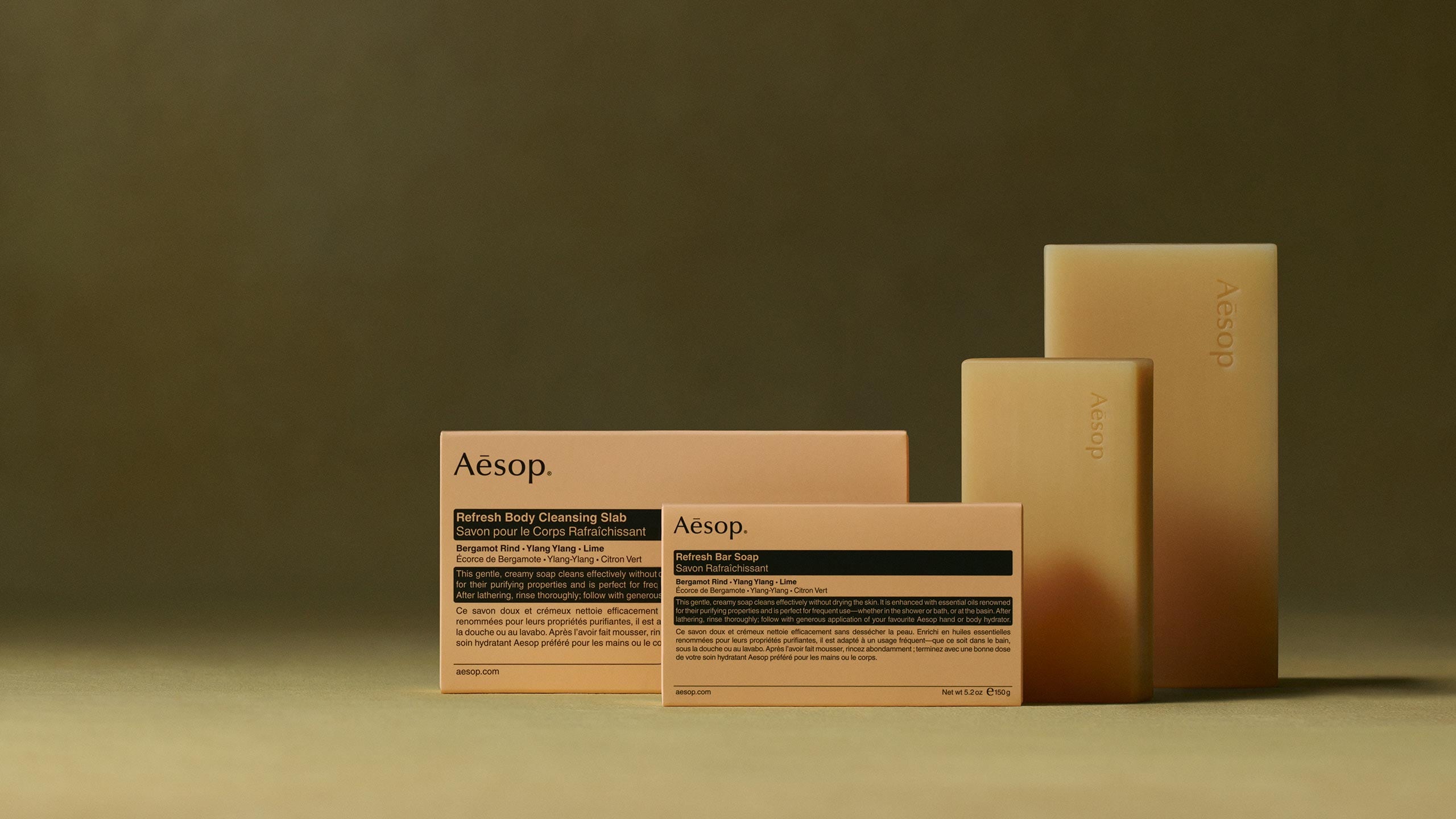 Aesop refresh bar soap and its packaging placed in front of a green textured background