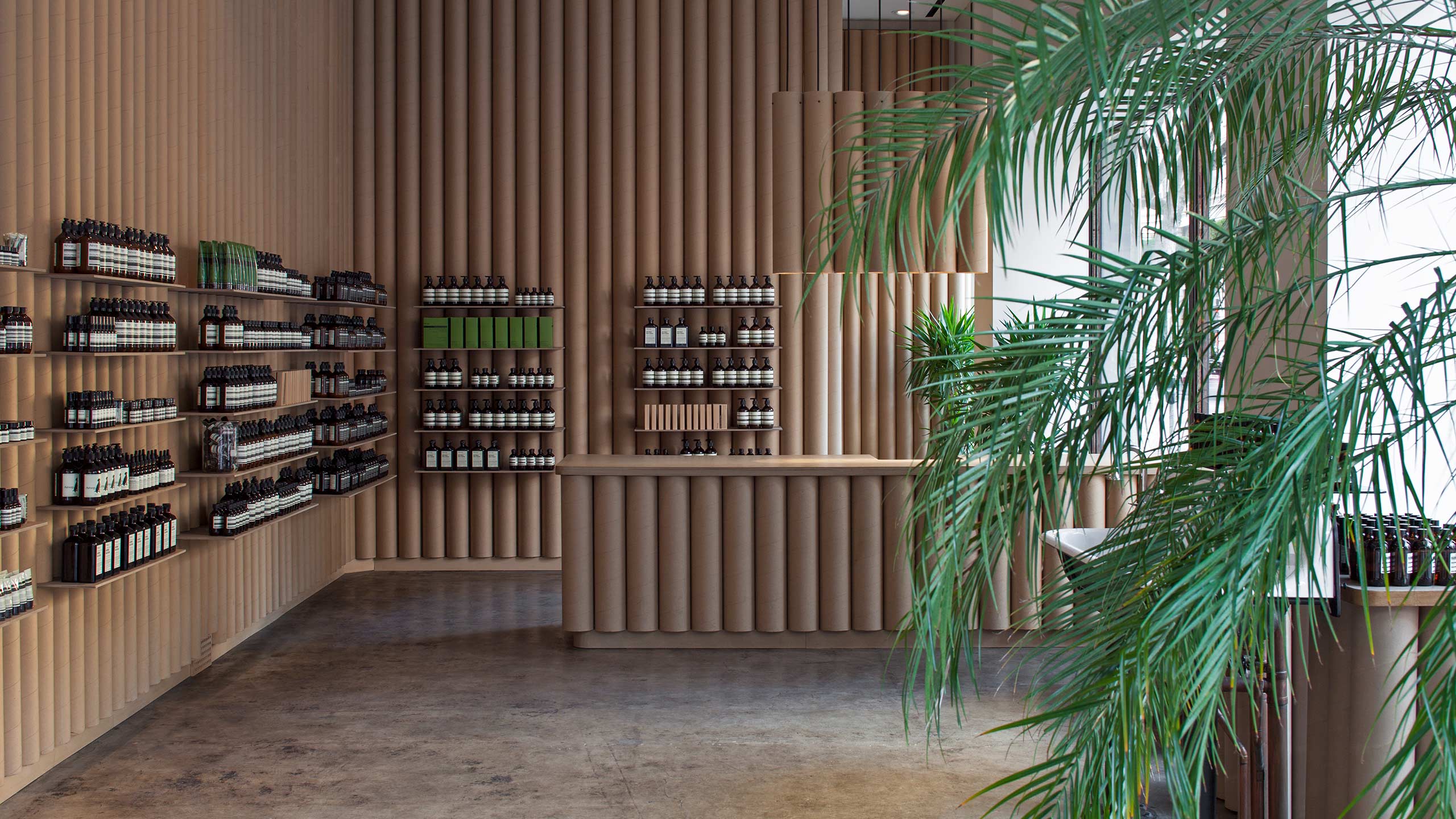 A concrete shop floor fitted with walls made from cylinder cardboard tubes.