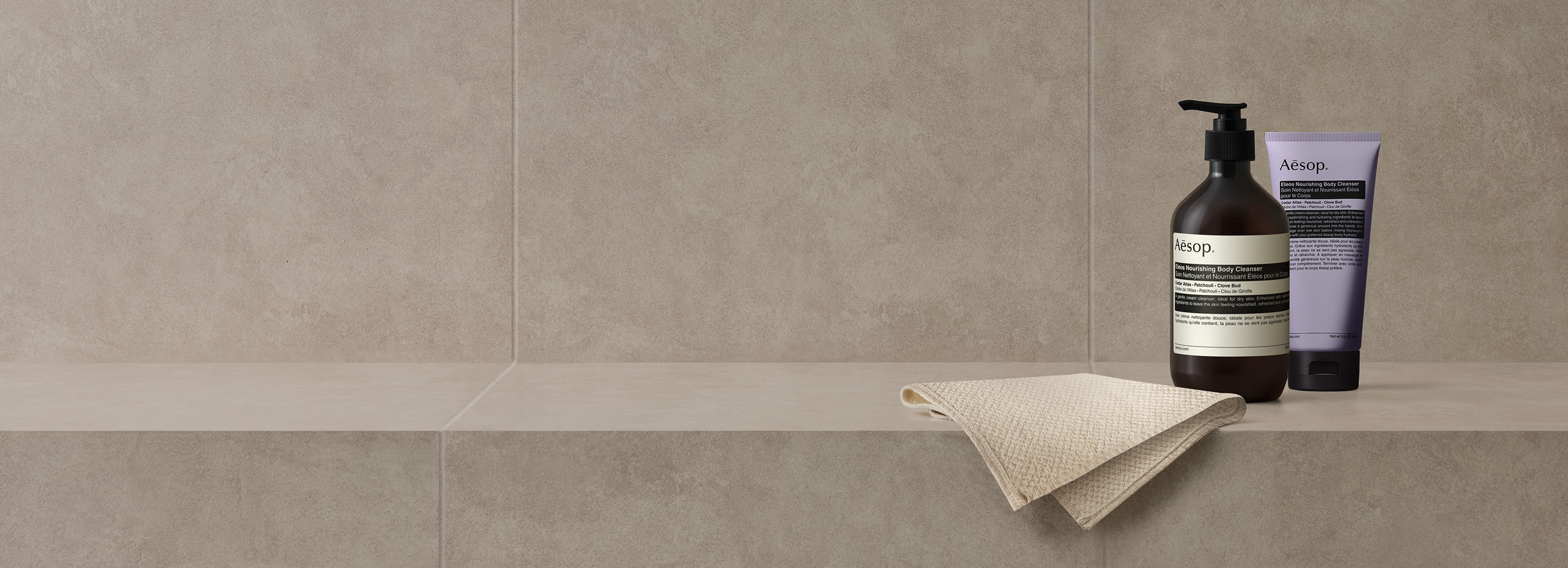 Eleos nourishing body cleansers placed next to Aesop face cloth