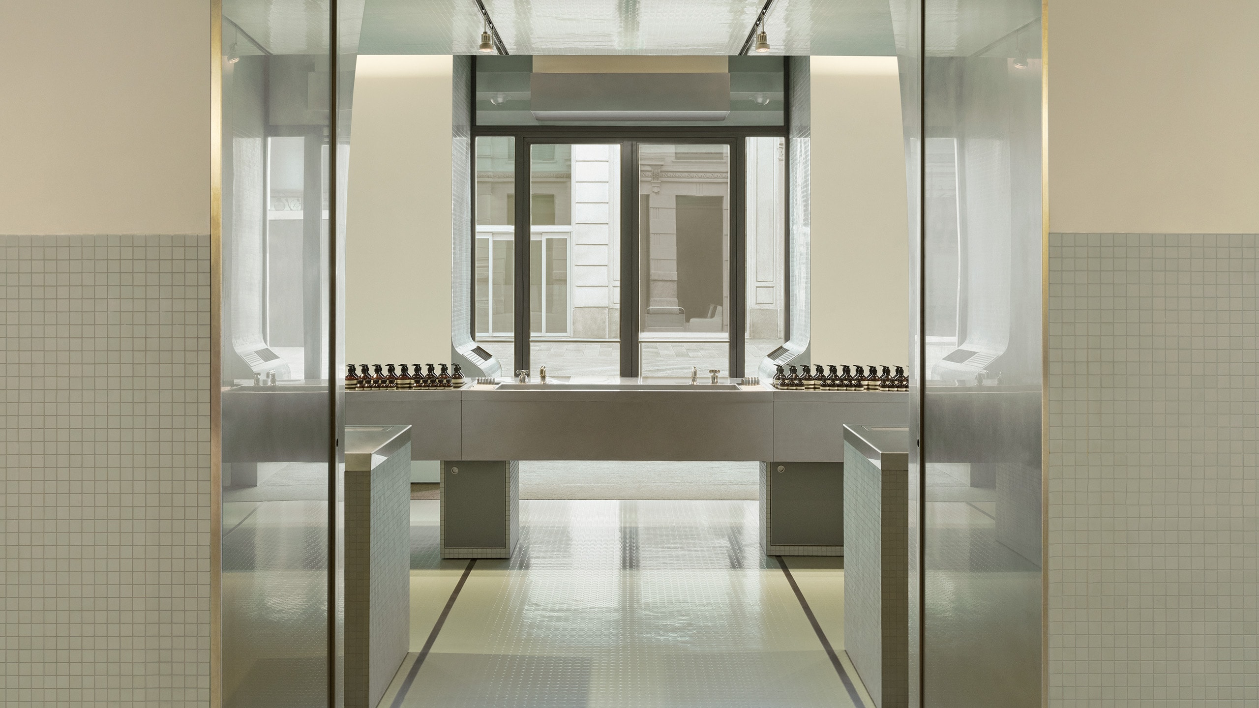 Aesop Milano Cordusio store interior made of rubber, stone and metal. View from the interior doors and out the window onto the street.