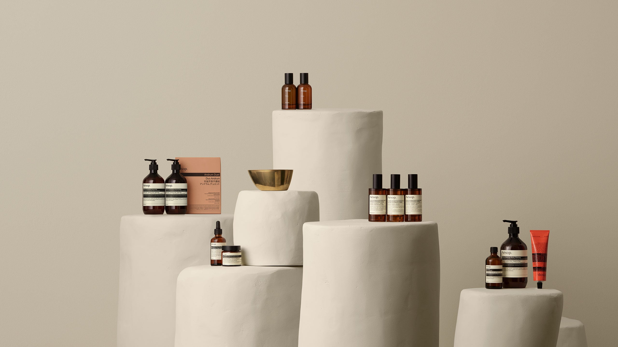 Aesop products placed on a white stone pillars