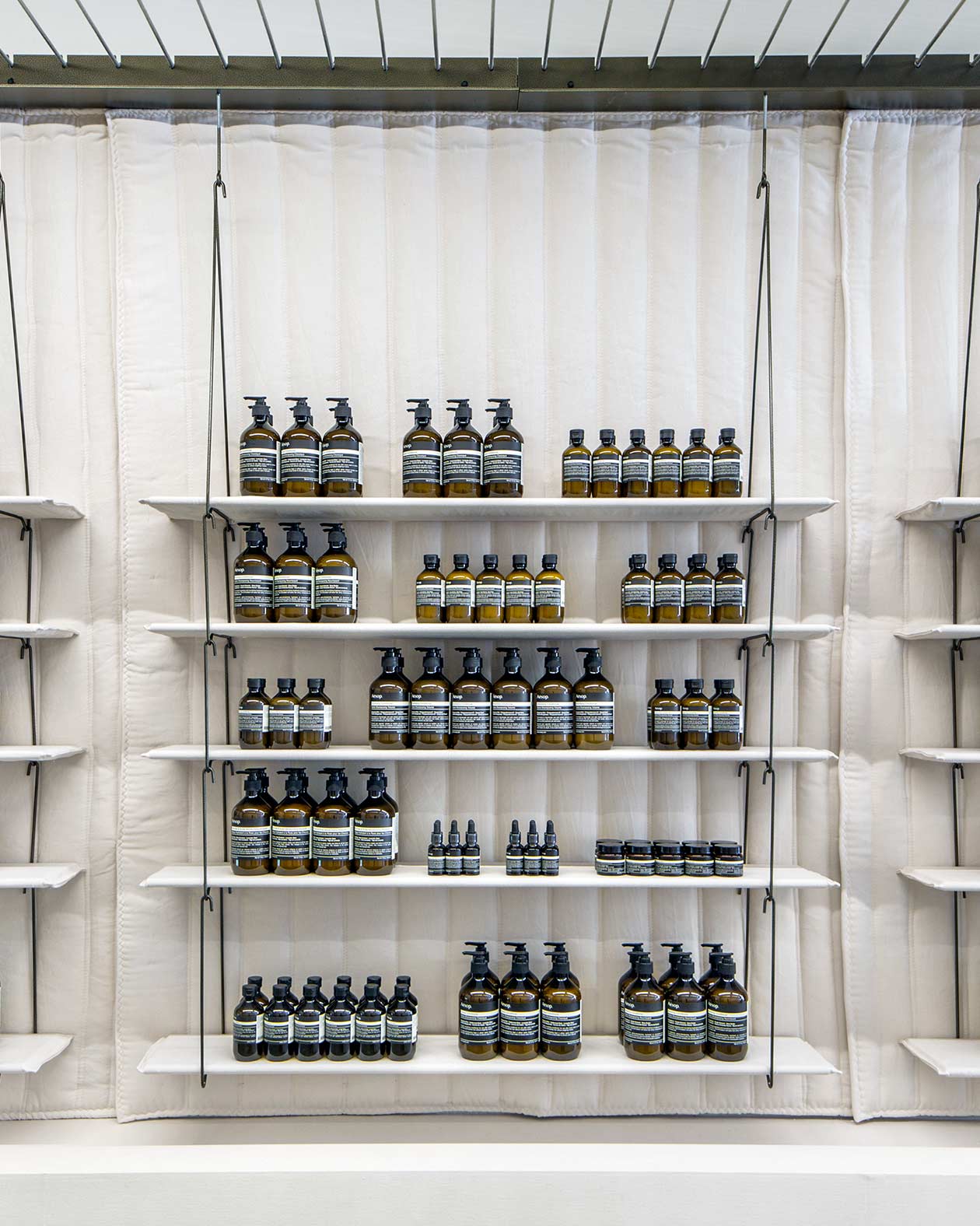 White string shelving holding Aesop product.