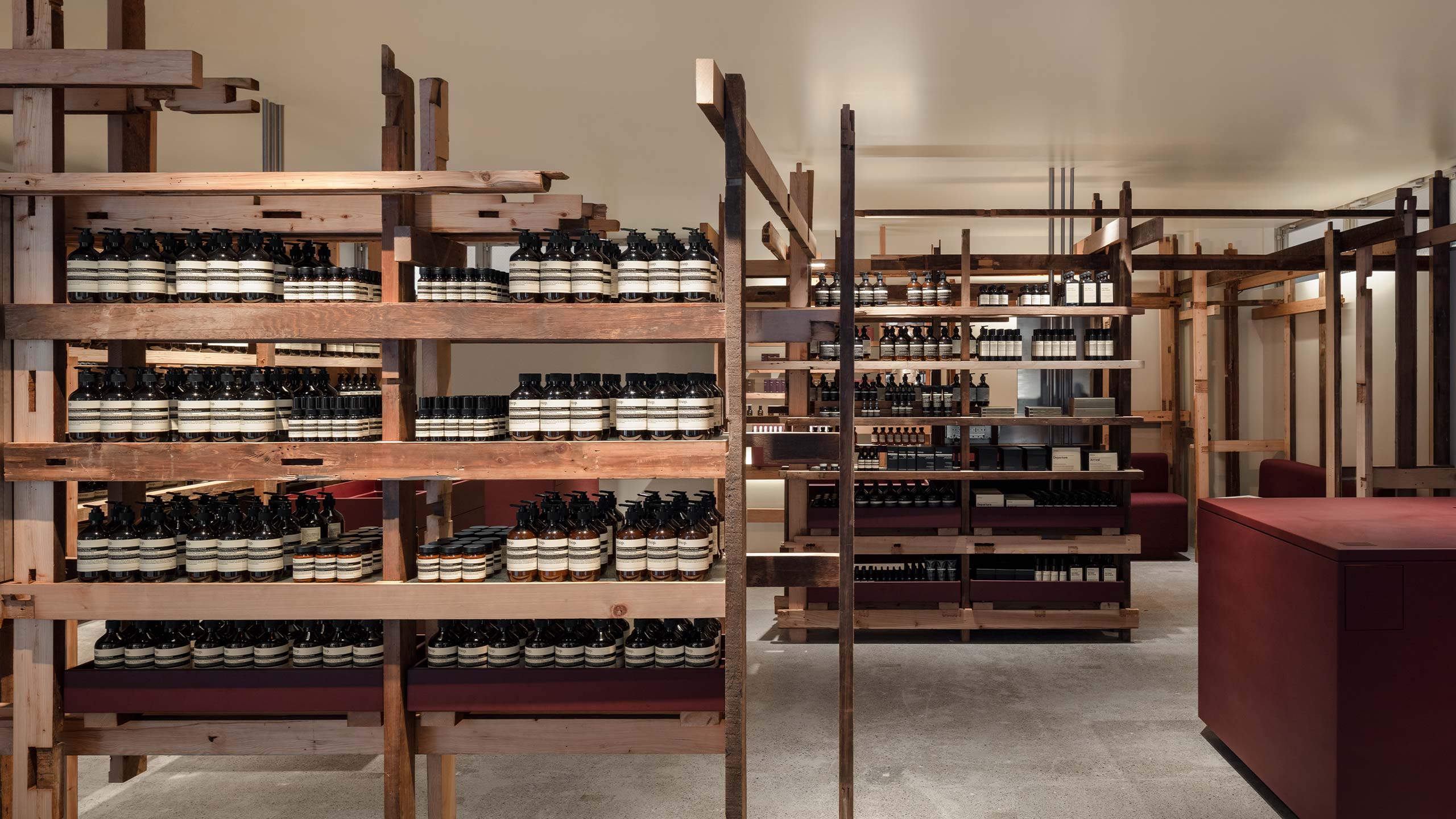 A series of shelves with Aesop products that are staggered throughout the space creating a multitude of pathways and alcoves