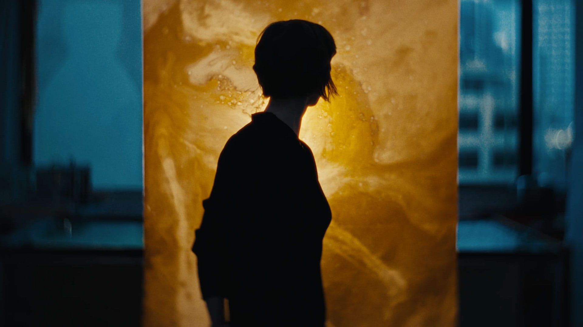 Silhouette of Jessie French in front of a sheet of algae-based bioplastic.