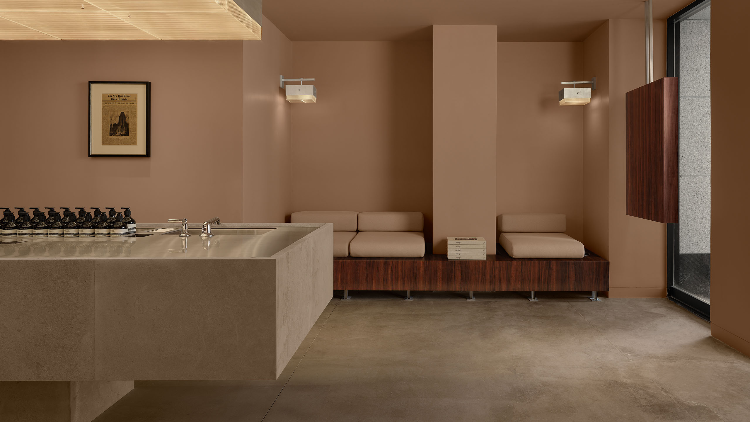 store interior featuring concrete floor, large granite basin, and inset couch seating area